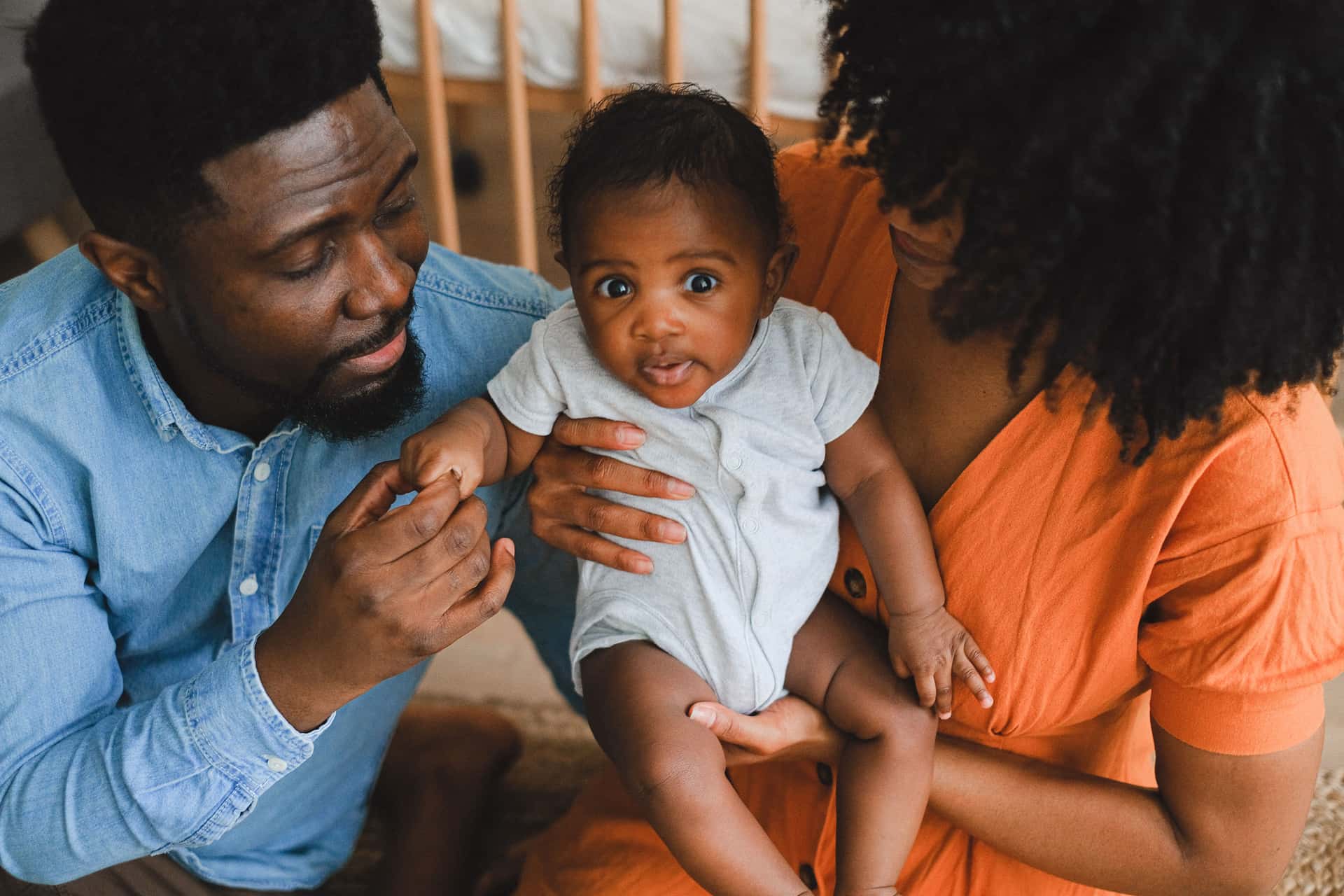 A parent reading gear notes beside a baby at home